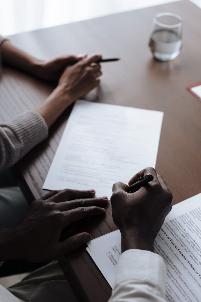 Intimate scene of a couple signing important adoption documents at home, highlighting diversity and parenting.
